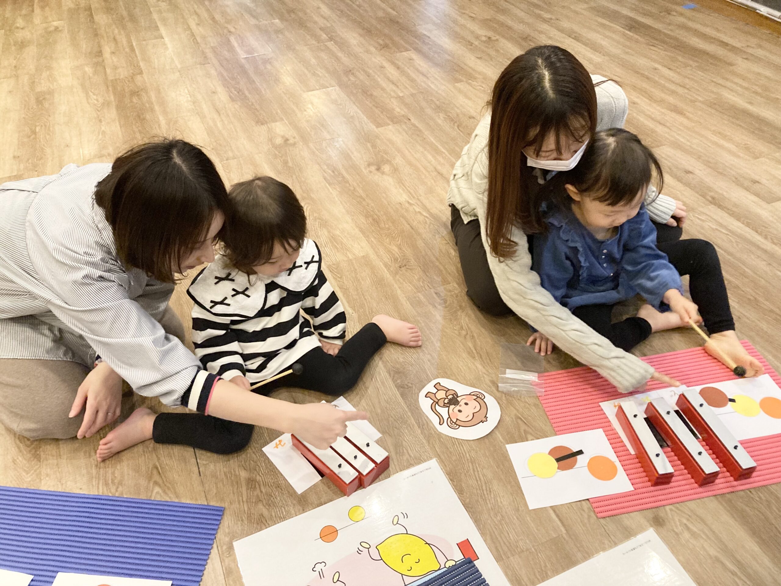 鉄琴の演奏に挑戦する子どもとサポートする親の様子。