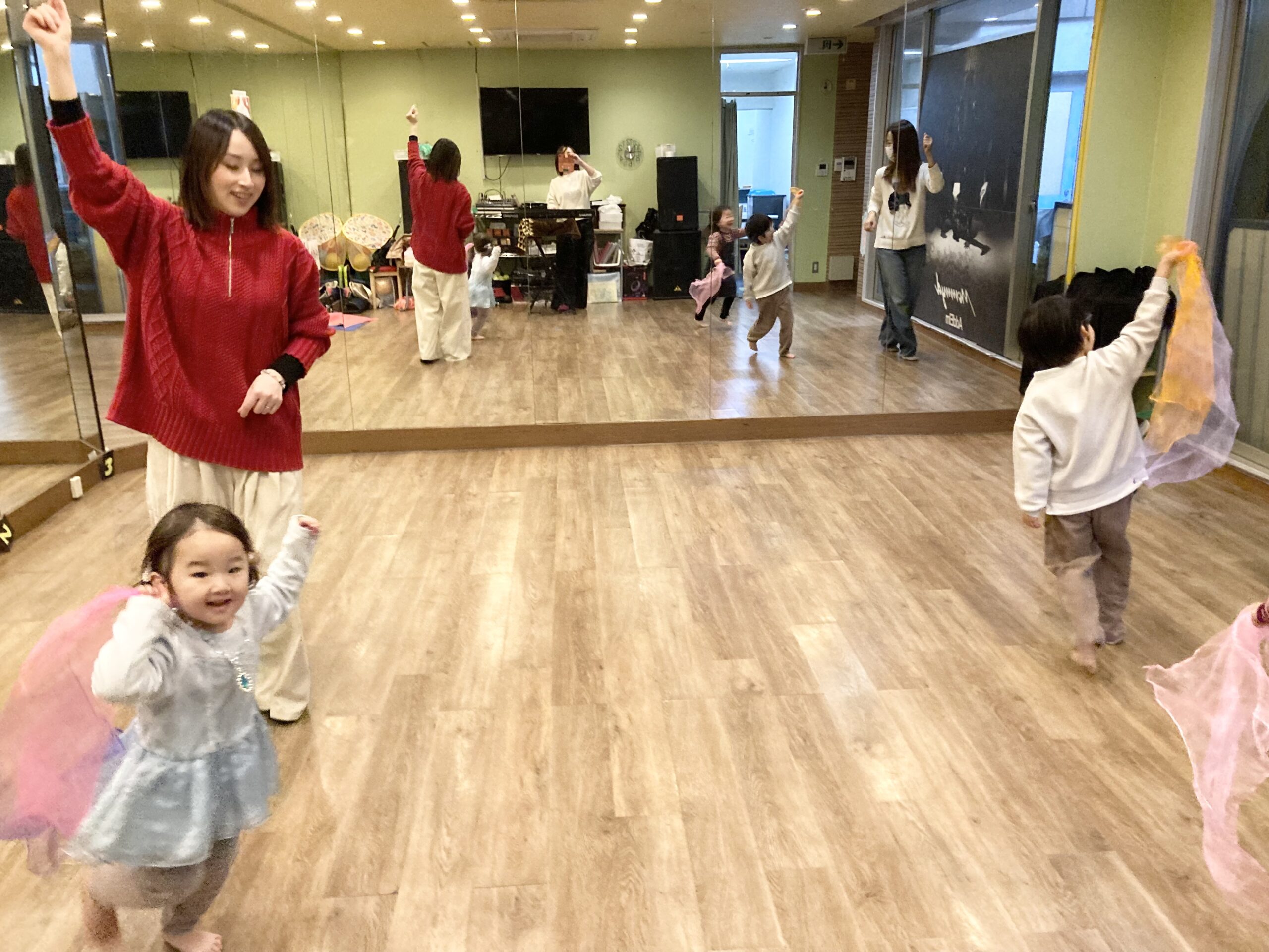 音楽を感じながら親子でスカーフを振り表現するリトミックレッスンの様子